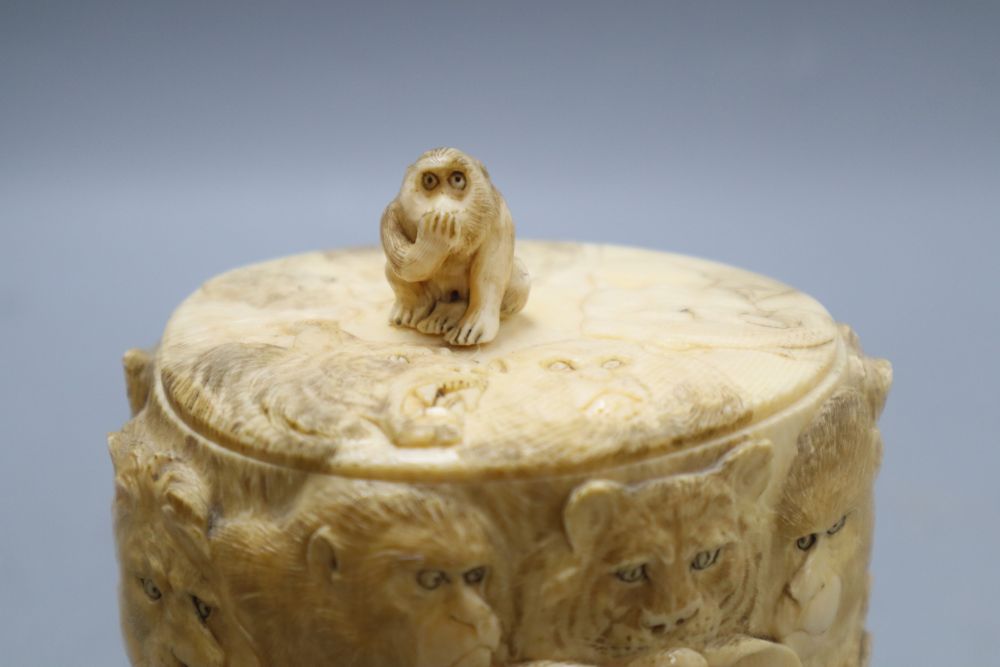 A Japanese ivory box and cover, Meiji Period, carved with elephants, lions, monkeys, etc. (lacking base), overall height including lid